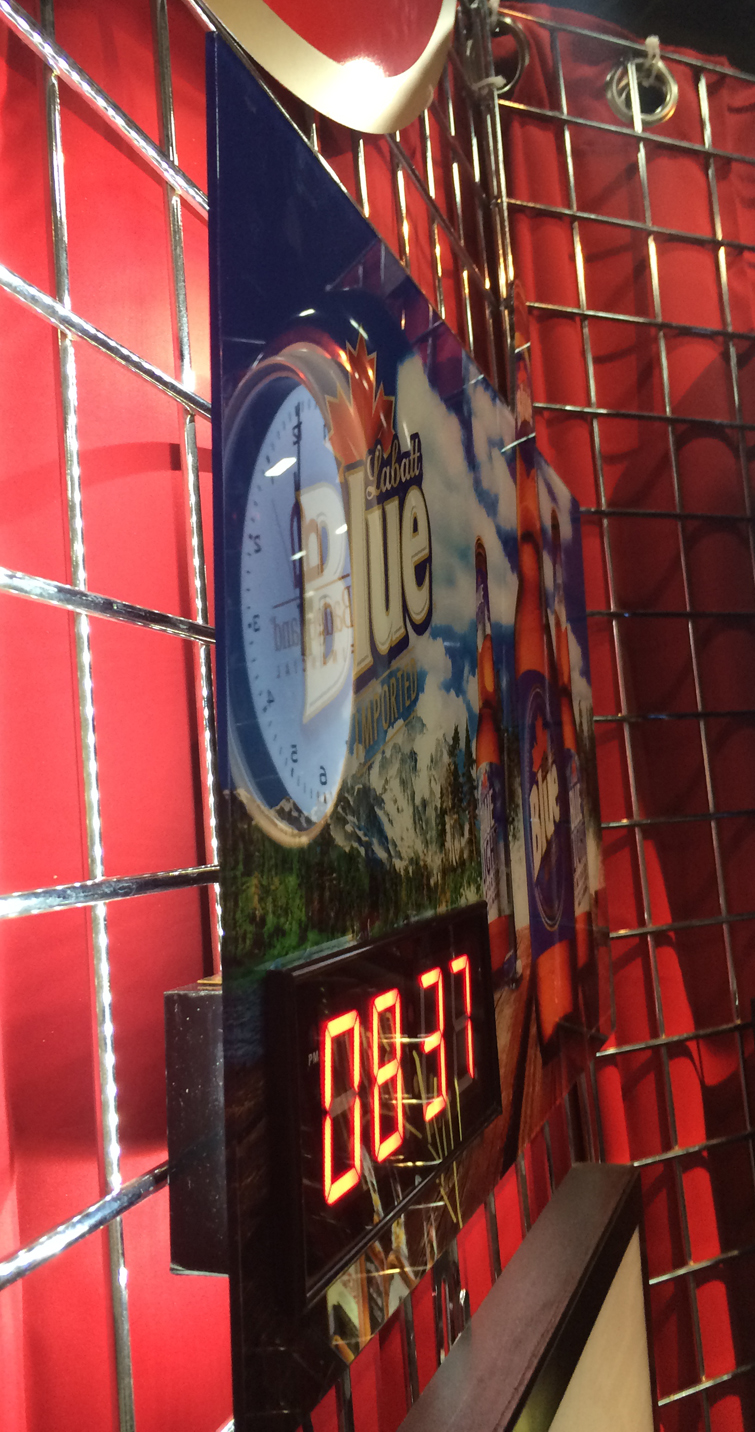 Side view of glossy wooden sign with LED clock.